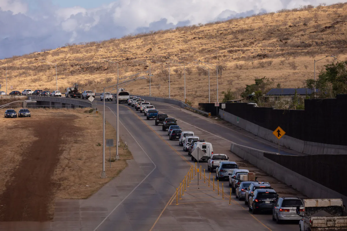 Cars wait in line on Lahaina Bypass road to go to Lahaina in the aftermath of the Maui wildfires in Lahaina, Hawaii, on Aug. 16, 2023. (Photo by Yuki IWAMURA / AFP) 