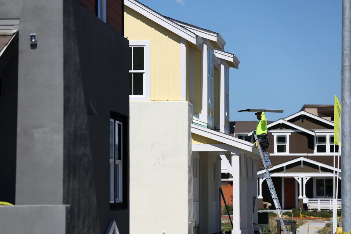 A construction worker carries materials as he works on a home under construction at a housing development in Petaluma, Calif., on March 23, 2022. (Justin Sullivan/Getty Images)