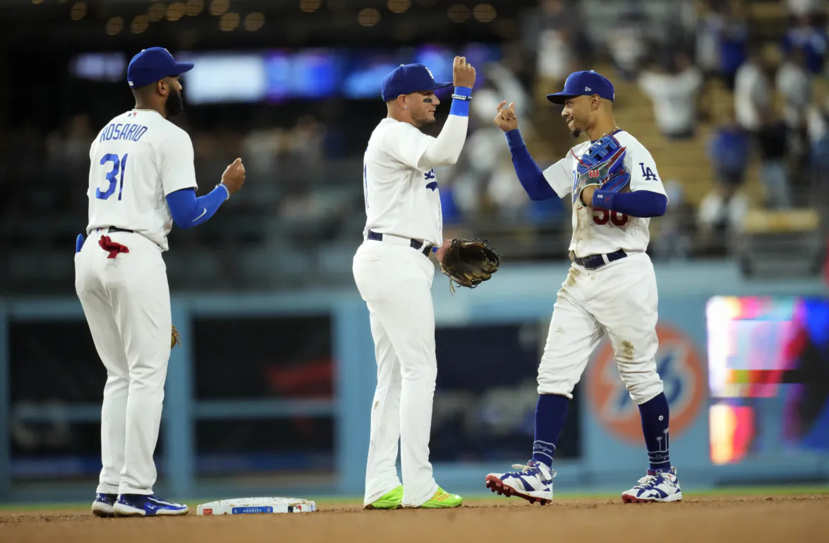 Mookie Betts (50),  Miguel Rojas (11) and Amed Rosario (31) of the Los Angeles Dodgers celebrate a win over the Milwaukee Brewers at Dodger Stadium in Los Angeles on Aug. 16, 2023. (Kevork Djansezian/Getty Images)