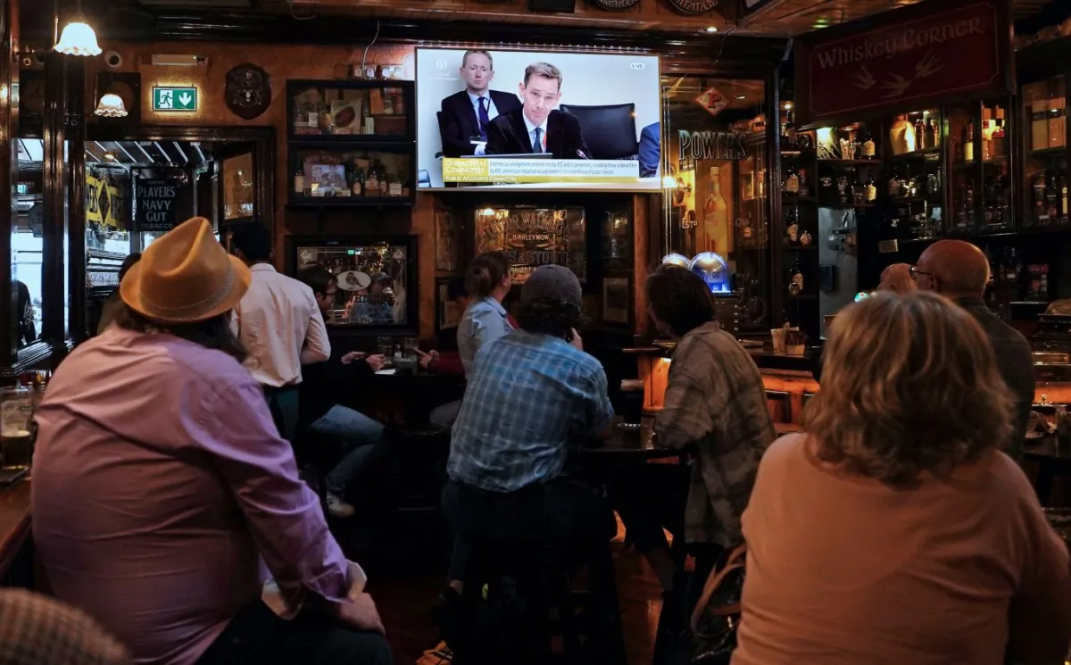 People watching television coverage of Ryan Tubridy giving evidence to a parliamentary committee, in Doheny and Nesbitts pub in Dublin, Republic of Ireland, on July 11, 2023. (PA).