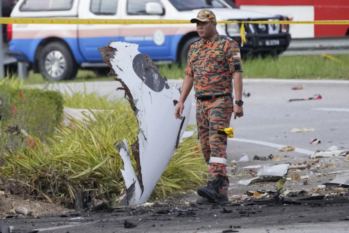 A member of the fire and rescue department inspect the crash site of a small plane in Shah Alam district, Malaysia, on Aug. 17, 2023. (Vincent Thian/AP Photo)