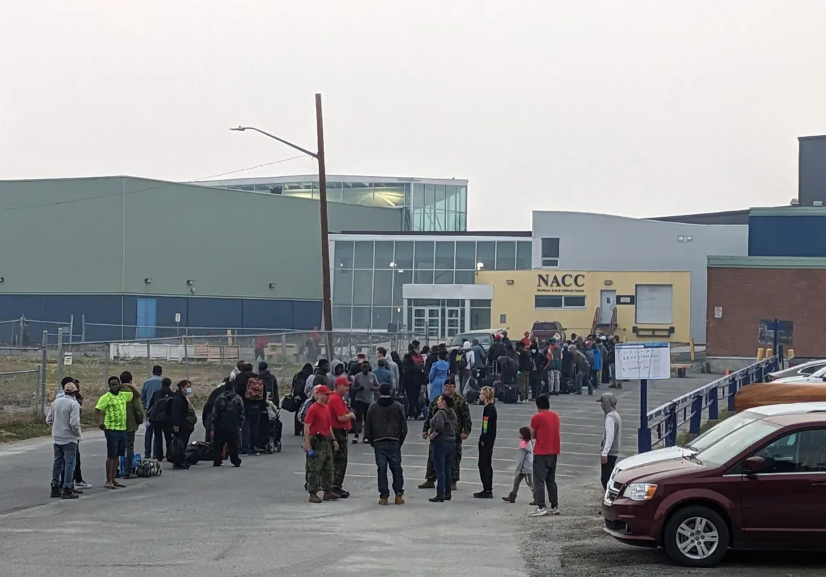 People without vehicles line up to register for a flight to Calgary in Yellowknife on Aug. 17, 2023. (The Canadian Press/Bill Braden)
