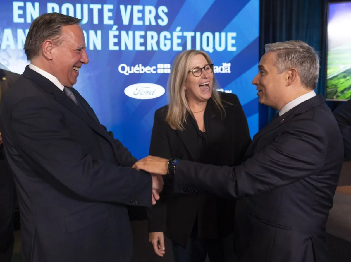 Lisa Drake, centre, vice-president of EV Industrialization for Ford Model e, speaks with Quebec Premier François Legault, left, and Minister of Innovation, Science and Industry François-Philippe Champagne regarding a car battery plant in Becancour, Que.,  Aug.17, 2023. (The Canadian Press/Christinne Muschi)