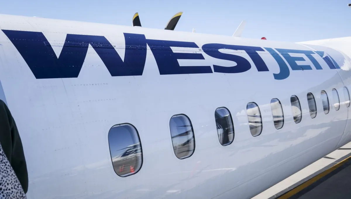 A WestJet plane waits at a gate at Calgary International Airport in Calgary on Aug. 31, 2022. (Jeff McIntosh/The Canadian Press)