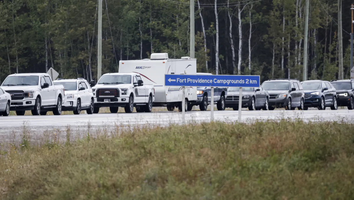 Vehicles line-up for fuel at Fort Providence, N.W.T., on the only road south from Yellowknife, Aug. 17, 2023, as the city is evacuated due to wildfires in the region. (THE CANADIAN PRESS/Jeff McIntosh)