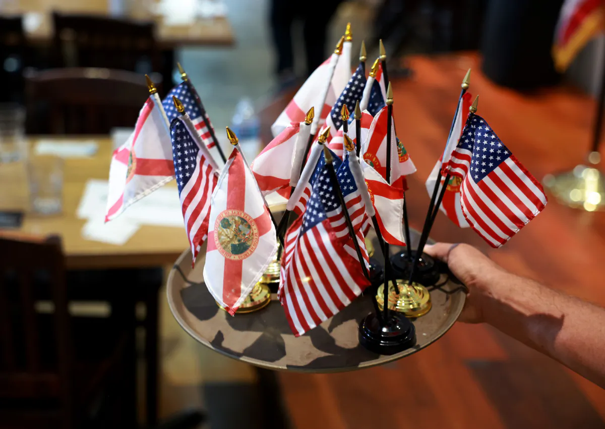 American flags along with the Florida state flag are carried in a tray at a political campaign event in Miami, Fla., on Aug. 18, 2023. (Joe Raedle/Getty Images)