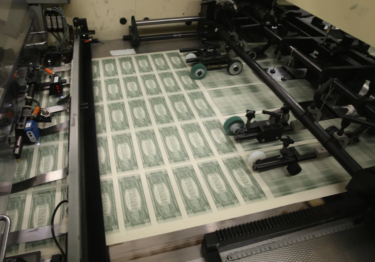 Sheets of one dollar bills run through the printing press at the Bureau of Engraving and Printing in Washington, on March 24, 2015. (Mark Wilson/Getty Images)