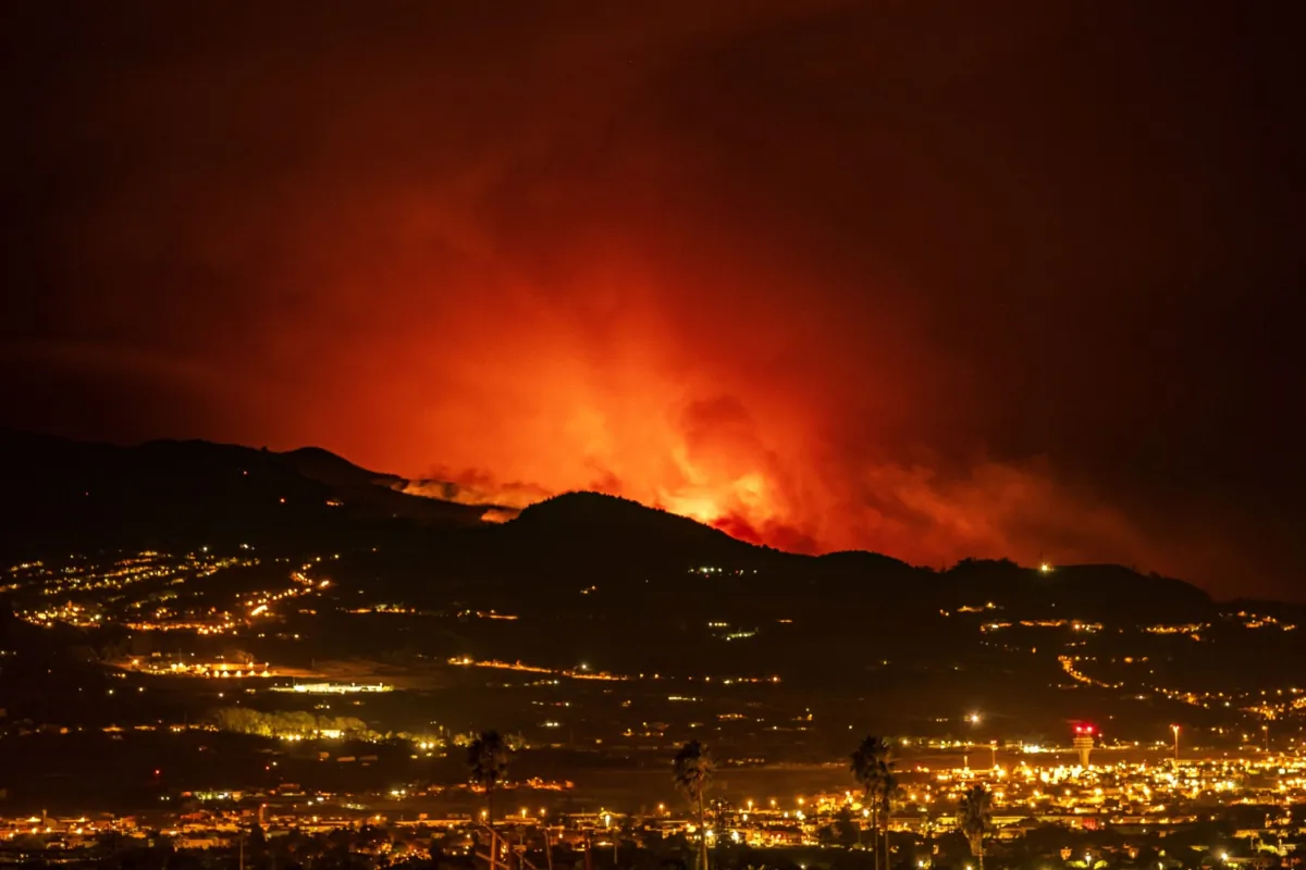 Flares on the horizon as the fire advances through the forest toward the town of La Laguna and Los Rodeos airport in Tenerife, Canary Islands, Spain, on Aug. 19, 2023. (Arturo Rodriguez/AP Photo)