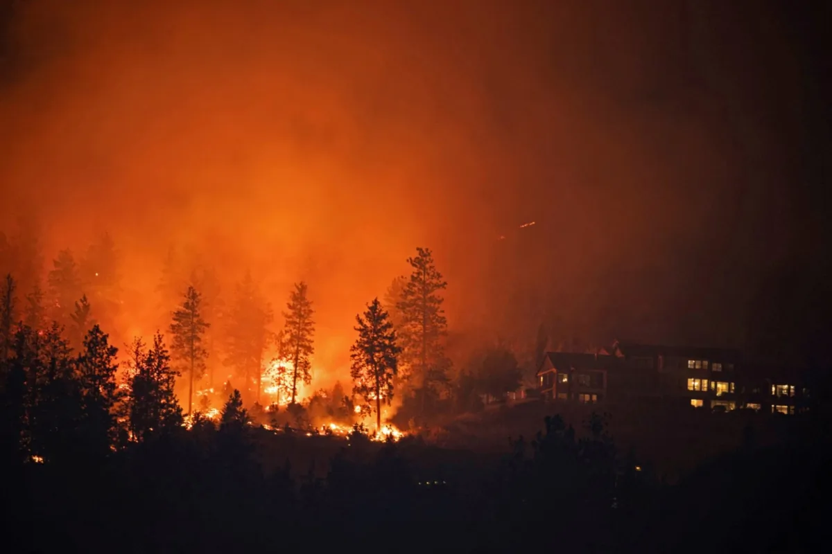 The McDougall Creek wildfire burns next to houses in the Okanagan community of West Kelowna, B.C., on Aug. 19, 2023. (Chris Helgren/Reuters)