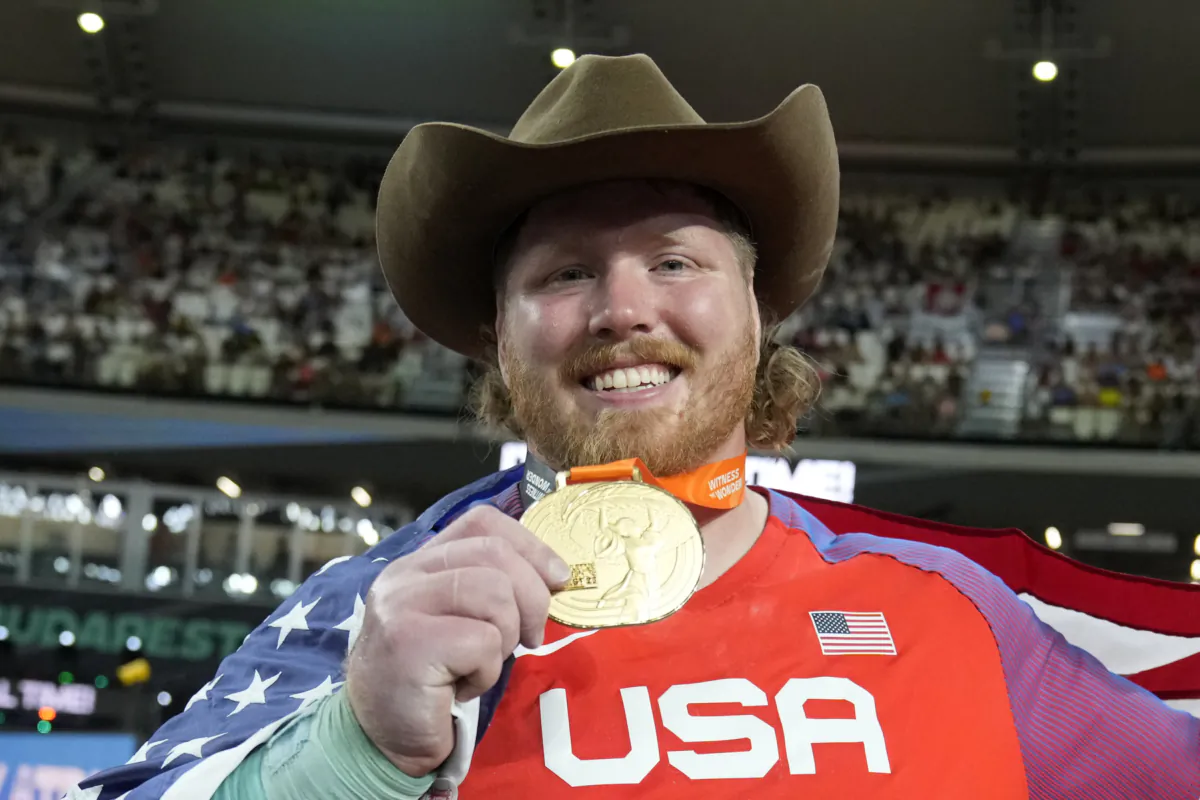 Ryan Crouser, of the United States, poses after winning the gold medal and setting a new championship record in the Men's shot put final during the World Athletics Championships in Budapest, Hungary, on Aug. 19, 2023. (Matthias Schrader/AP Photo)