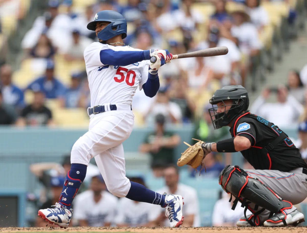 Mookie Betts (50) of the Los Angeles Dodgers hits a two run single in front of Jacob Stallings (58) of the Miami Marlins, to take a 3-1 lead during the eighth inning, at Dodger Stadium in Los Angeles on August 19, 2023. (Harry How/Getty Images)
