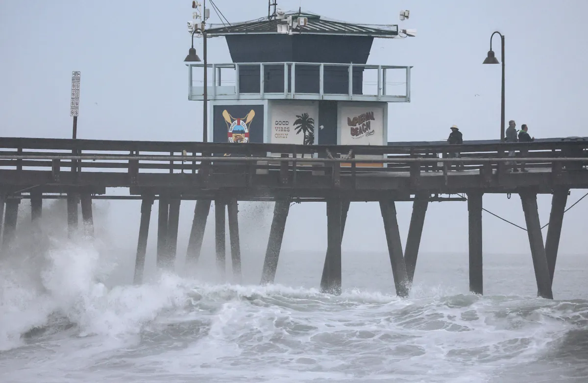 People stand on a pier over the Pacific Ocean with Tropical Storm Hilary approaching San Diego County in Imperial Beach, Calif., on Aug. 20, 2023. (Mario Tama/Getty Images)