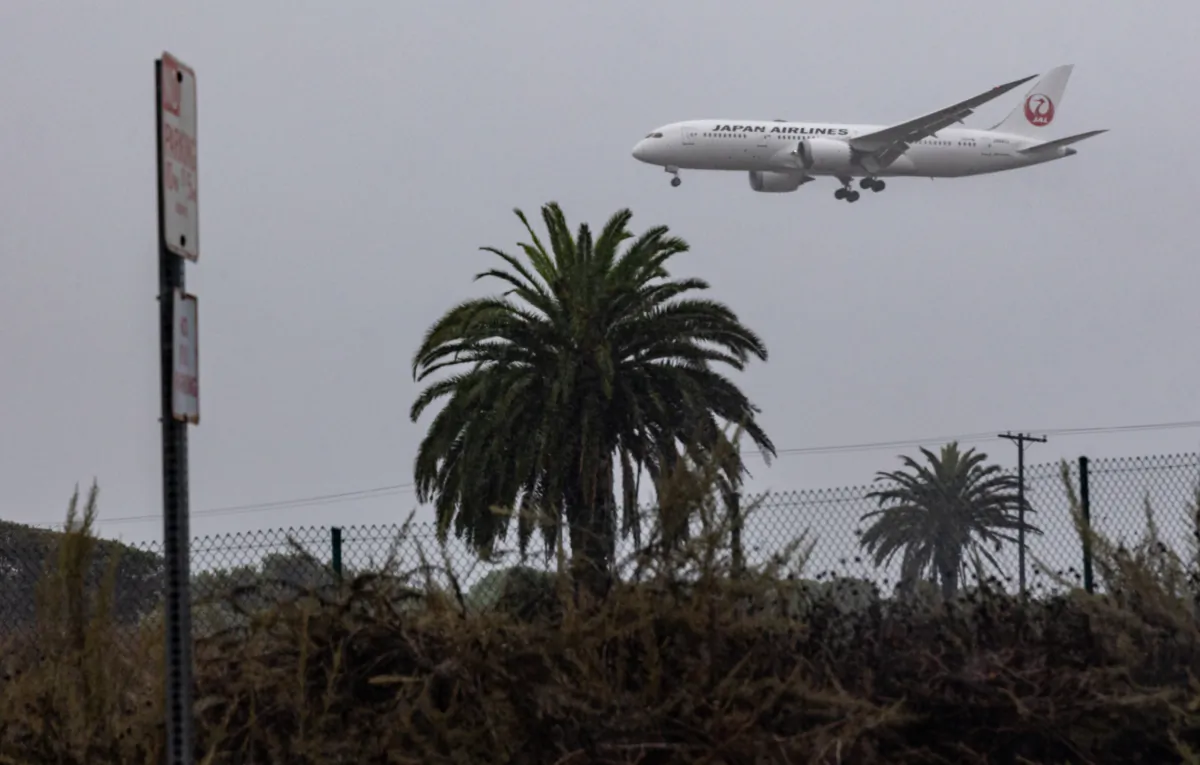 An airplane flies into Los Angeles International Airport through a storm caused by Tropical Storm Hilary in Los Angeles on Aug. 20, 2023. (John Fredricks/The Epoch Times)