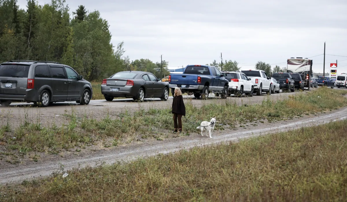 Vehicles line up for fuel at Fort Providence, N.W.T., as people flee Yellowknife on the only road south, on Aug. 17, 2023. (The Canadian Press/Jeff McIntosh)