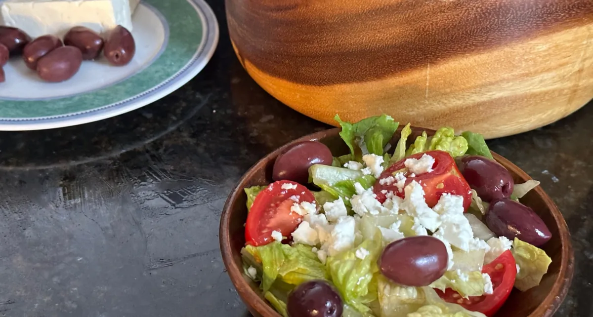 Howard's Garlic Salad is a simple mix of lettuce, tomato, and onions dressed in a vinaigrette, topped with olives and feta on the side. (Ari LeVaux)