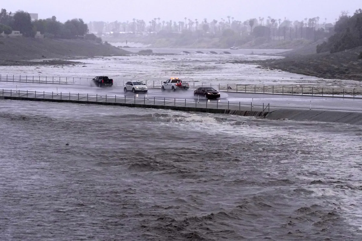 Vehicles cross over a flood control basin that has almost reached the street in Palm Desert, Calif., on Aug. 20, 2023. (Mark J. Terrill/AP Photo)