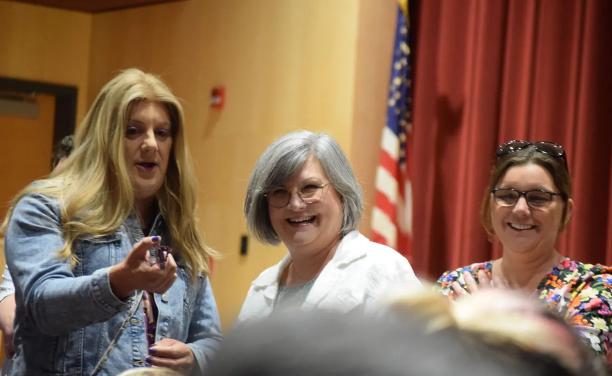 Tennis coach Sasha Yates (L) was surrounded by supporters who attended a Gettysburg Area School District school board meeting in Gettysburg, Pa., on Aug. 21, 2023. (Beth Brelje/The Epoch Times)