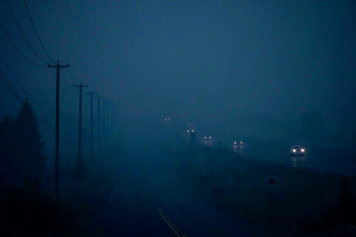 Thick smoke from wildfires burning in the area hangs in the air as motorists travel on the Trans-Canada Highway east of Kamloops, B.C., on Aug. 20, 2023. (The Canadian Press/Darryl Dyck)