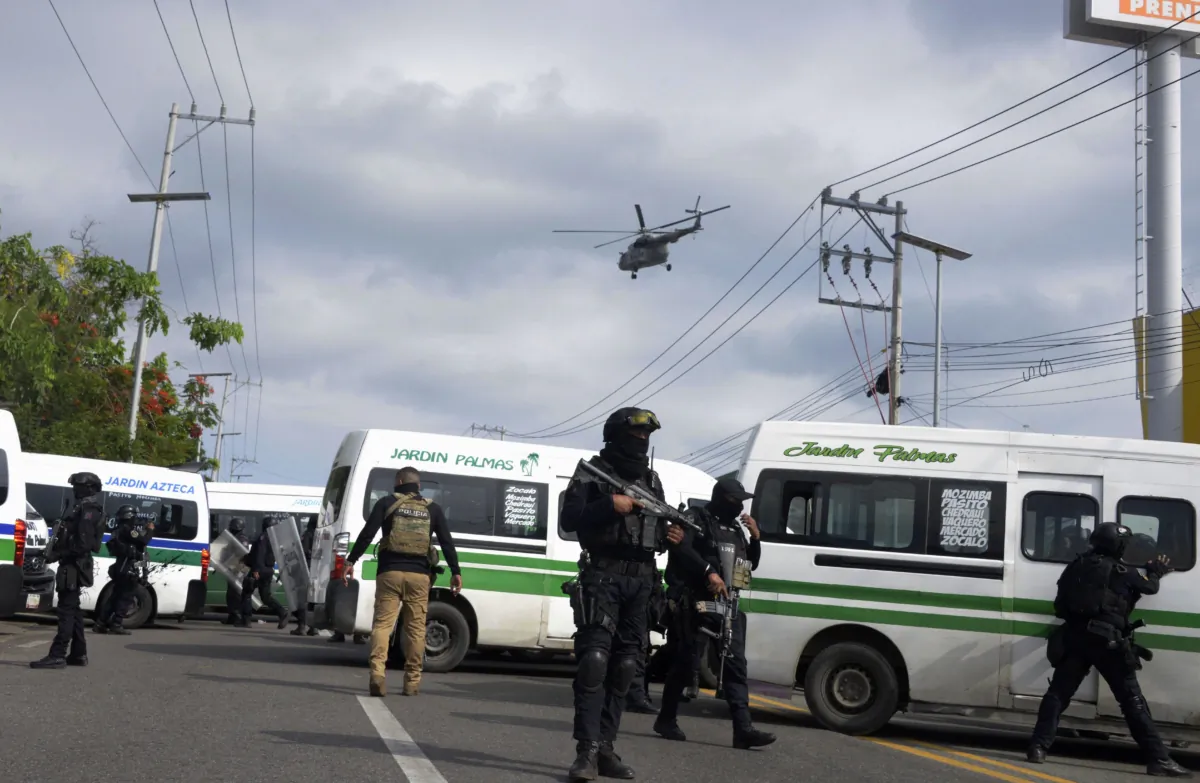 Police guard the site where armed men set fire to vehicles following a blockade by public transport workers in Acapulco, Guerrero State, Mexico, on Aug. 2, 2023. (Francisco Robles/AFP via Getty Images)
