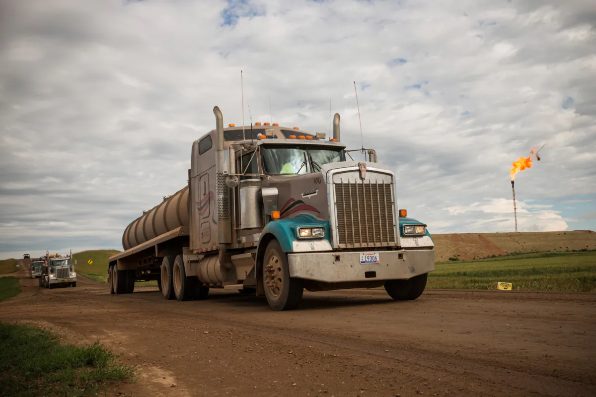 A line of trucks drives past a gas flare outside Watford City, N.D., on July 23, 2013. (Andrew Burton/Getty Images)
