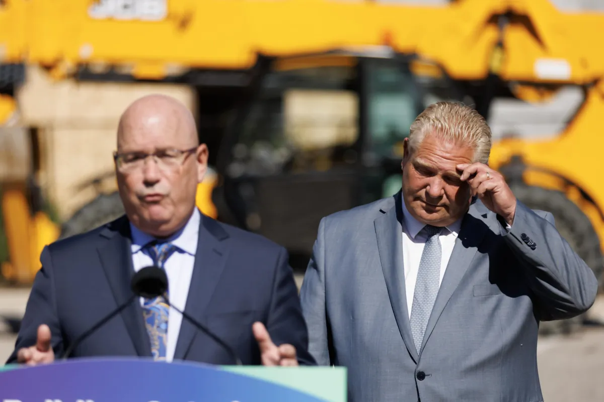 Ontario Premier Doug Ford listens as Ontario’s minister of housing Steve Clark speaks during a press conference in Mississauga, Ont., on Aug. 11, 2023. (The Canadian Press/Cole Burston)
