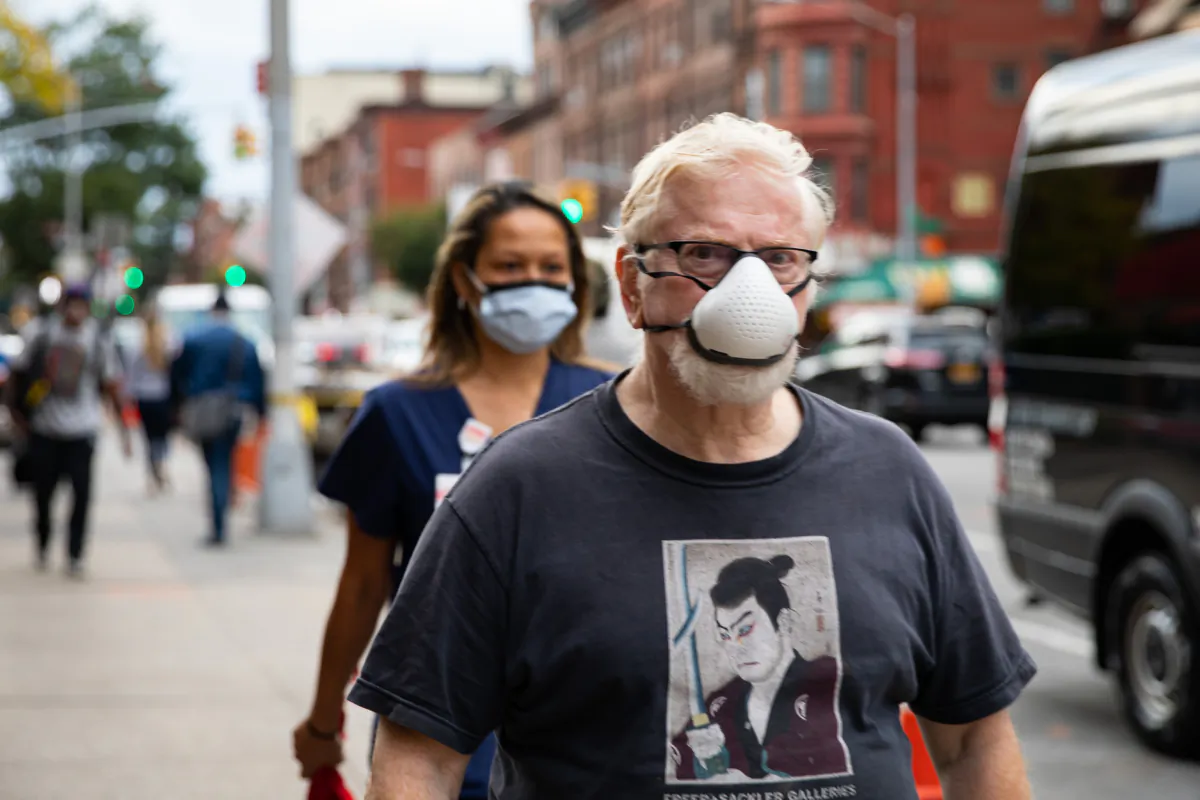 People wearing face masks walk on the street in a file photo. (Chung I Ho/The Epoch Times)