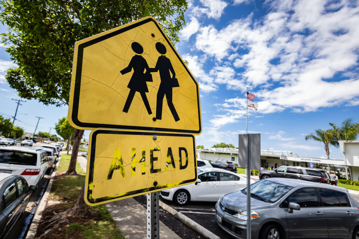 A pedestrian sign outside a school in Costa Mesa, Calif., on Aug. 21, 2023. (John Fredricks/The Epoch Times)