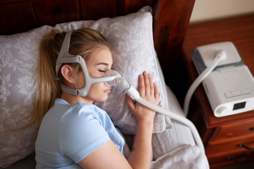 Young female sleeping with cpap machine for sleep apnea.(Independence_Project/Shutterstock)