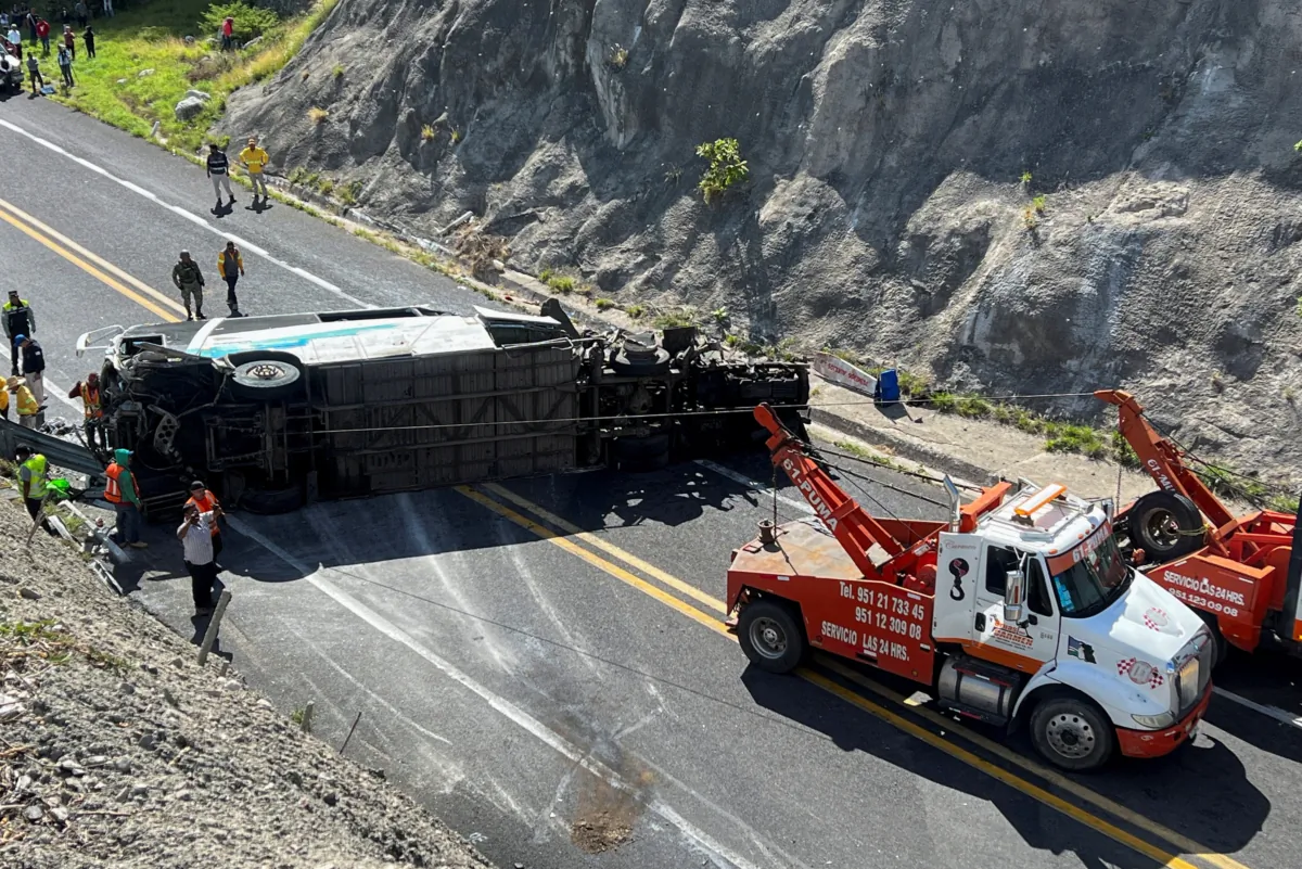 Tow trucks and authorities work at the area of a road accident, which left over a dozen migrants dead, in Tepelmeme Villa de Morelos, in Oaxaca state, Mexico, on Aug. 22, 2023. (Jose de Jesus Cortes/Reuters)