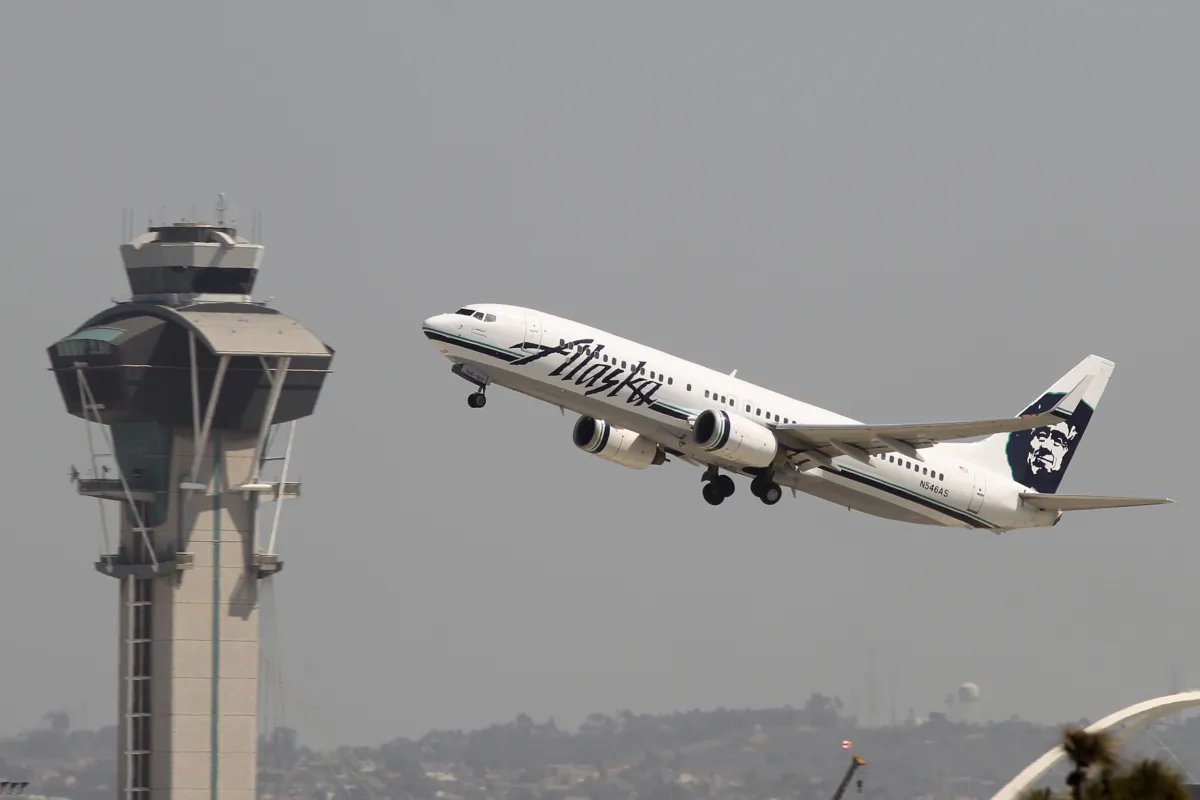 An Alaska Airlines jet passes the air traffic control tower at Los Angles International Airport (LAX) during take-off on April 22, 2013. (David McNew/Getty Images)