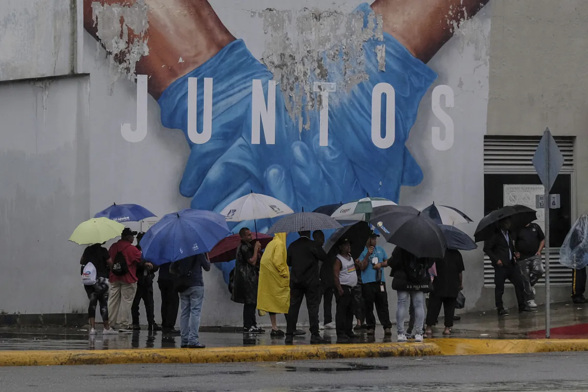 People wait for the metro to open amid rain brought by Tropical Storm Franklin in Santo Domingo, Dominican Republic, on Aug. 23, 2023. (Ricardo Hernandez/AP Photo)