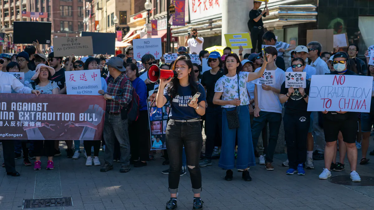 On the afternoon of June 9, 2019, Hong Kong people living in Boston and local Chinese gathered in front of the Massachusetts government building. The picture shows Hui Wing-ting holding a loudspeaker to call on everyone to support the "anti-extradition" campaign. (Liu Jingye/The Epoch Times)