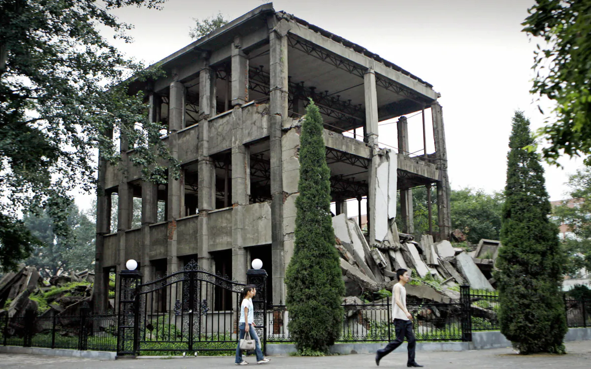Students walk past the ruins of the university library, now an earthquake memorial, on the university campus of Tangshan, in China's northeast Hebei Province, on July 19, 2006. Over 240,000 people died from a powerful earthquake that struck Tangshan city on July 28, 1976. (Peter Parks/AFP via Getty Images)
