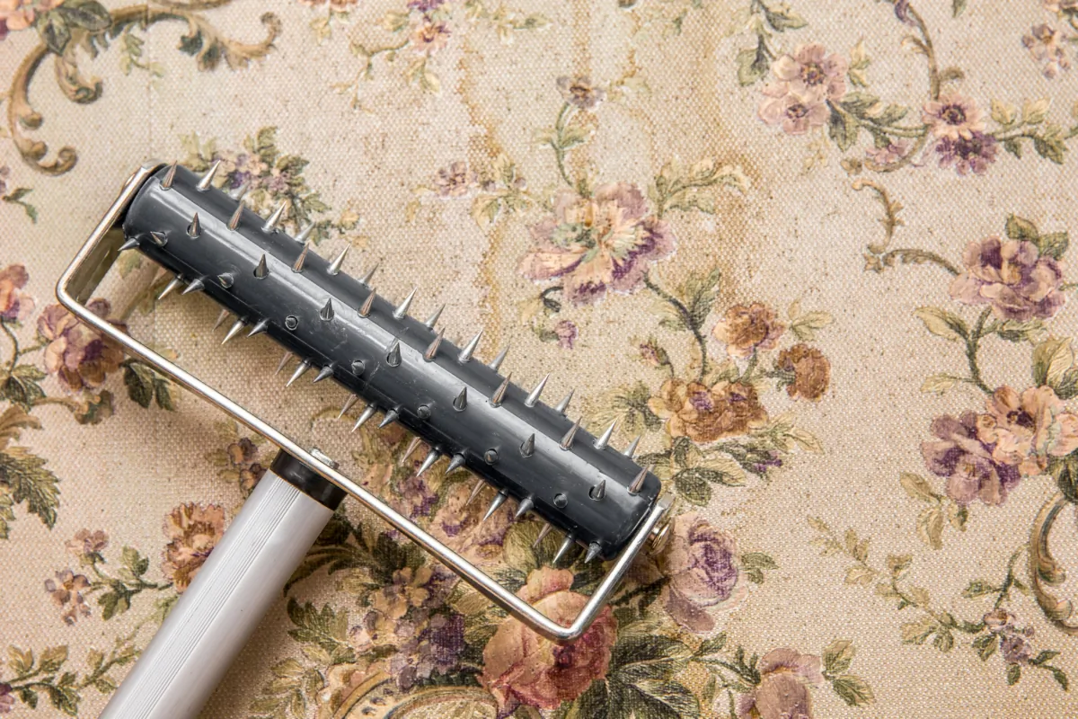 You can use scoring tools to help water and other liquids penetrate old wallpaper. (FotoHelin/Shutterstock)