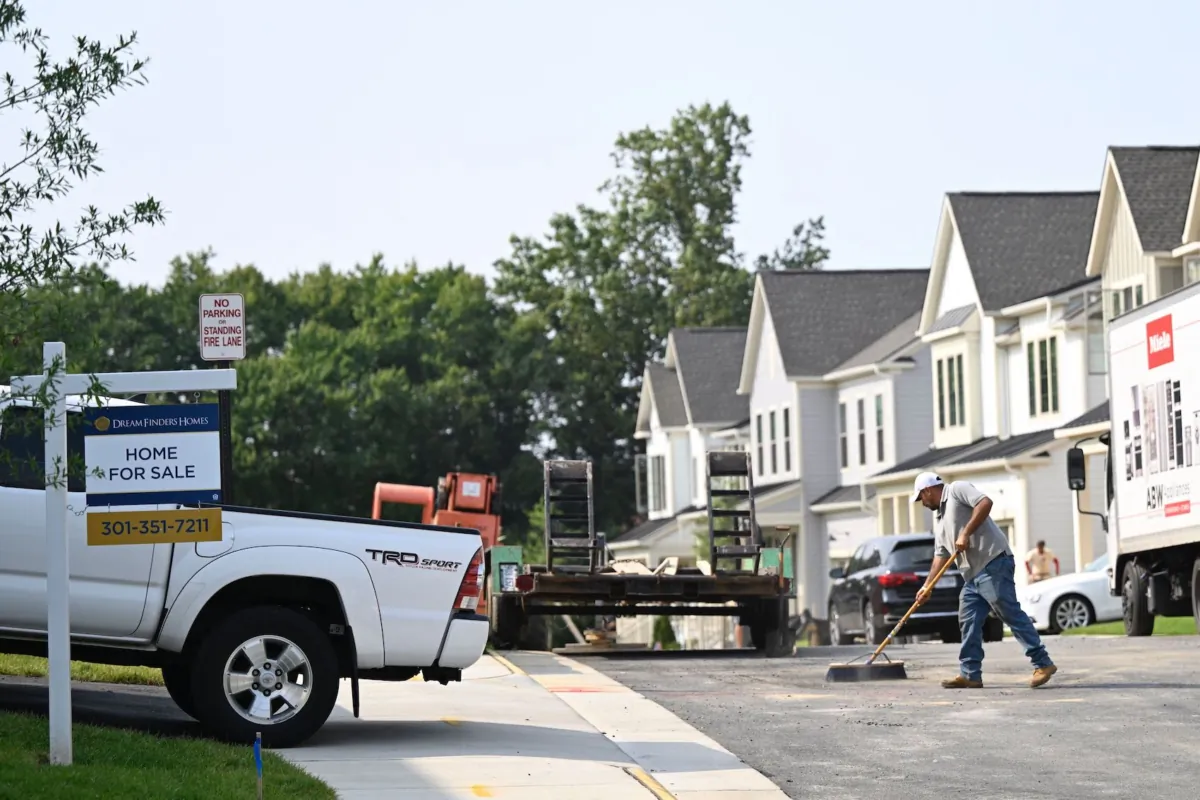 A 'for sale' sign is displayed in front of a new home in a housing development as a maintenance worker sweeps the street in Fairfax, Va., on Aug. 22, 2023. Sales of homes in the United States ticked down in July, according to industry data released on Aug. 22, 2023, as elevated mortgage rates and limited housing supply held buyers back. (Andrew Caballero-Reynolds/AFP via Getty Images)