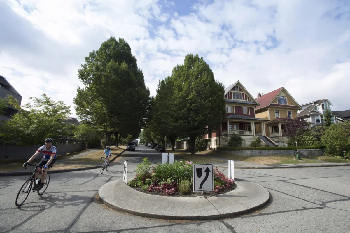 Cyclists ride past homes in a residential neighbourhood in Vancouver in a file photo. (The Canadian Press/Jonathan Hayward)