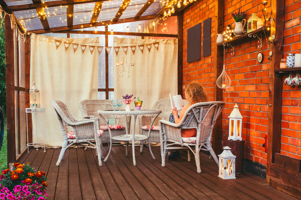 A serene backyard patio with comfortable seating and refreshing shade is the perfect place to host small gatherings or relax with a cool beverage.(FotoHelin/Shutterstock)
