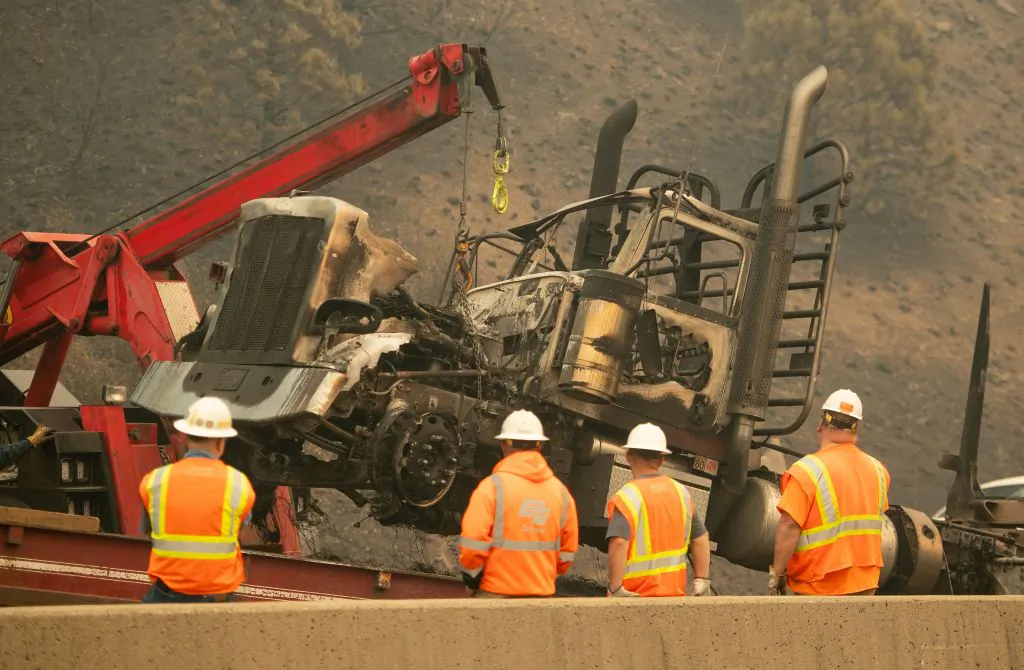 Caltrans workers remove a burned out truck along Interstate 5 during the Delta Fire near Delta, Calif., in the Shasta Trinity National Forest on Sept. 6, 2018. (Josh Edelson/AFP via Getty Images)