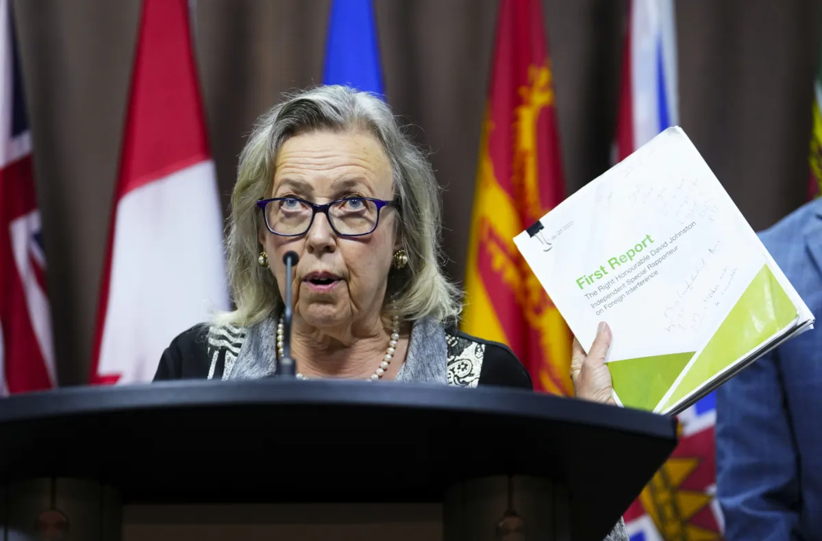 Green Party Leader Elizabeth May holds up David Johnston’s first report on foreign interference at a press conference on Parliament Hill in Ottawa on Aug. 18, 2023. (The Canadian Press/Sean Kilpatrick)