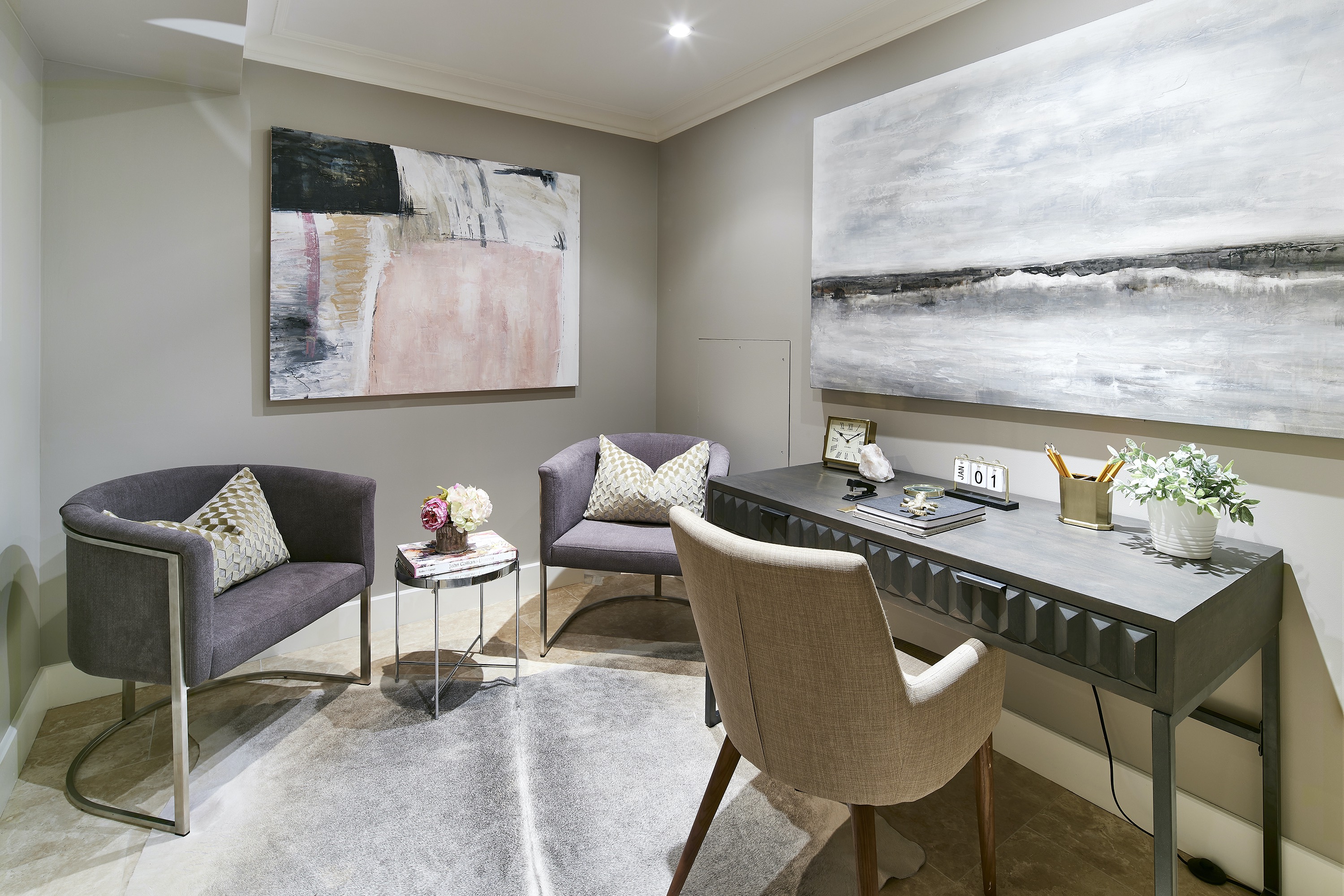 A lower-level windowless space is made light and bright through the use of overhead recessed lighting and light, neutral fabrics.
