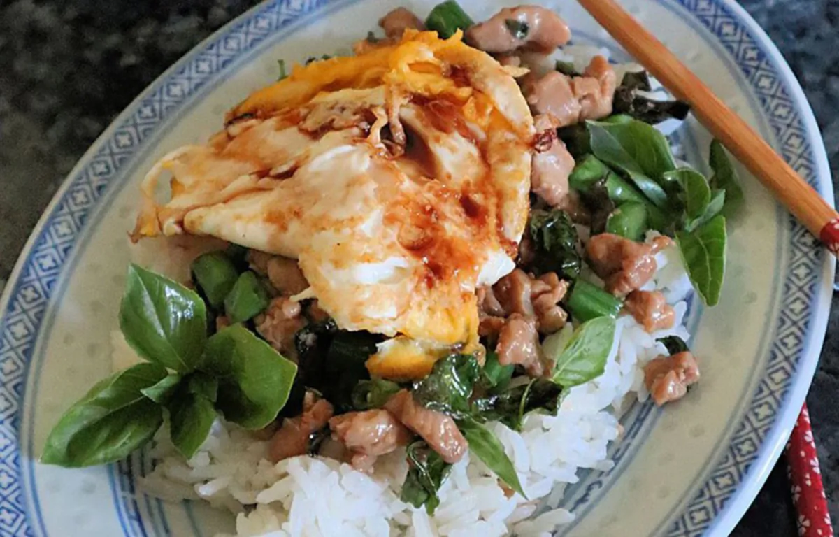 A crispy fried egg adds an extra pop of protein to this easy basil chicken stir-fry. (Gretchen McKay/Pittsburgh Post-Gazette/TNS)