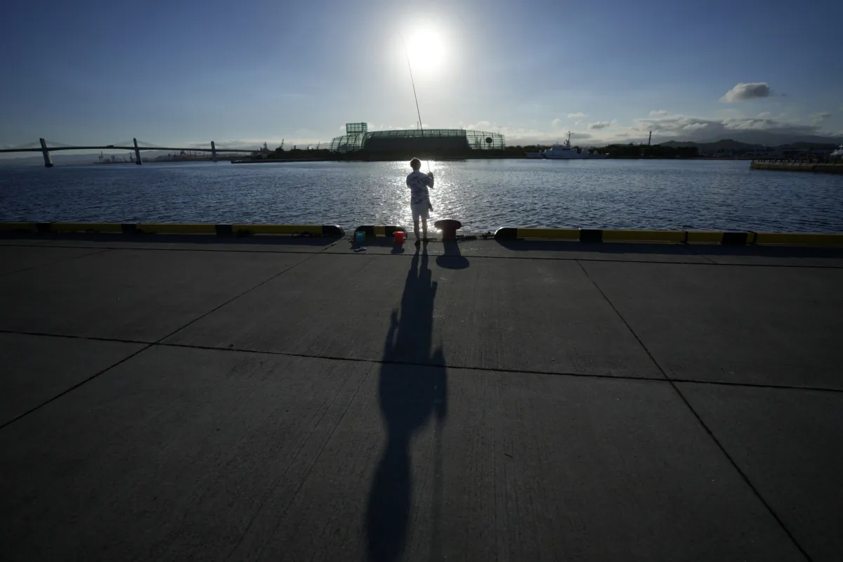 An angler fishes at Onahama Port in Iwaki, northeastern Japan, 68 kilometers (42 miles) from the Fukushima Daiichi nuclear power plant, on Aug. 25, 2023. (Eugene Hoshiko/AP Photo)