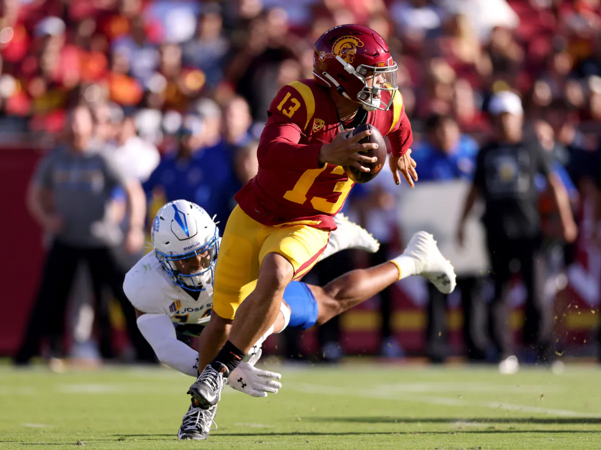 Caleb Williams (13) of the USC Trojans avoids the tackle against Elijah Wood (14) of the San Jose State Spartans during the second quarter at United Airlines Field at the Los Angeles Memorial Coliseum in Los Angeles on August 26, 2023. (Katelyn Mulcahy/Getty Images)