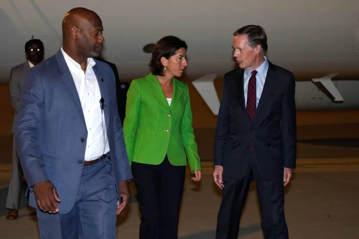 U.S. Secretary of Commerce Gina Raimondo (C) talks to U.S. Ambassador to China Nick Burns (R) as she arrives at the Beijing Capital International Airport in Beijing on Aug. 27, 2023. (Andy Wong/Pool/AFP via Getty Images)