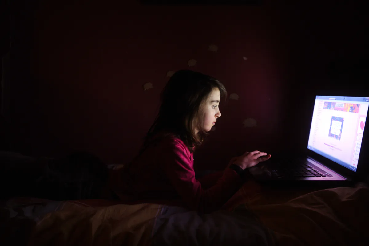 A girl plays video games on her computer in this file photo. It's important to establish limits on time allowed on computers as well as cell phones. (ALAIN JOCARD/AFP via Getty Images)