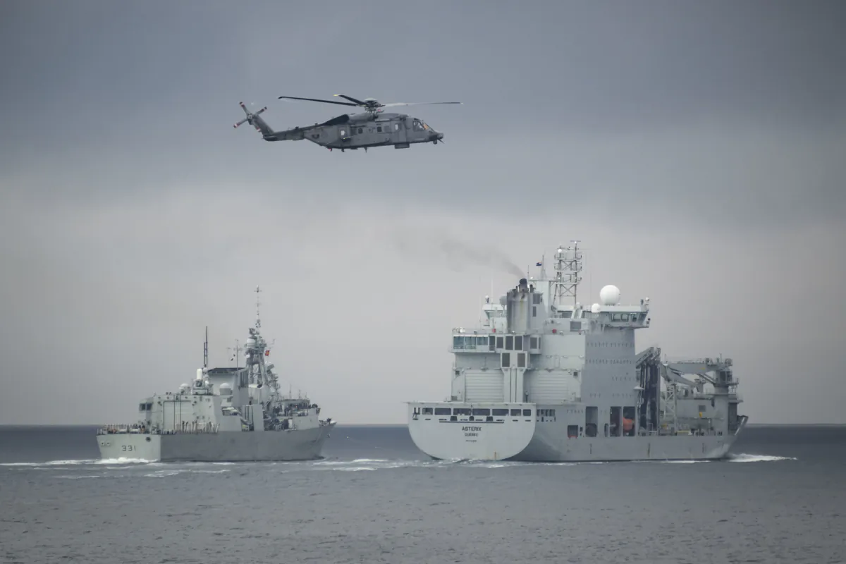 HMCS Ottawa’s embarked CH-148 Cyclone helicopter “Greywolf” conducts manoeuvres near HMCS Vancouver and MV Asterix while the two ships perform a Liquid Replenishment At Sea (L-RAS) during transit of the Pacific Ocean on Aug. 20, 2023. (Aviator Gregory Cole, Canadian Armed Forces Photo)
