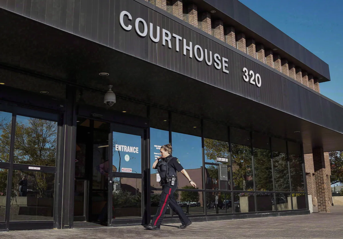 A police officer arrives at the provincial court building in Lethbridge, Alberta, on Sept. 23, 2015. (Jeff McIntosh/The Canadian Press)
