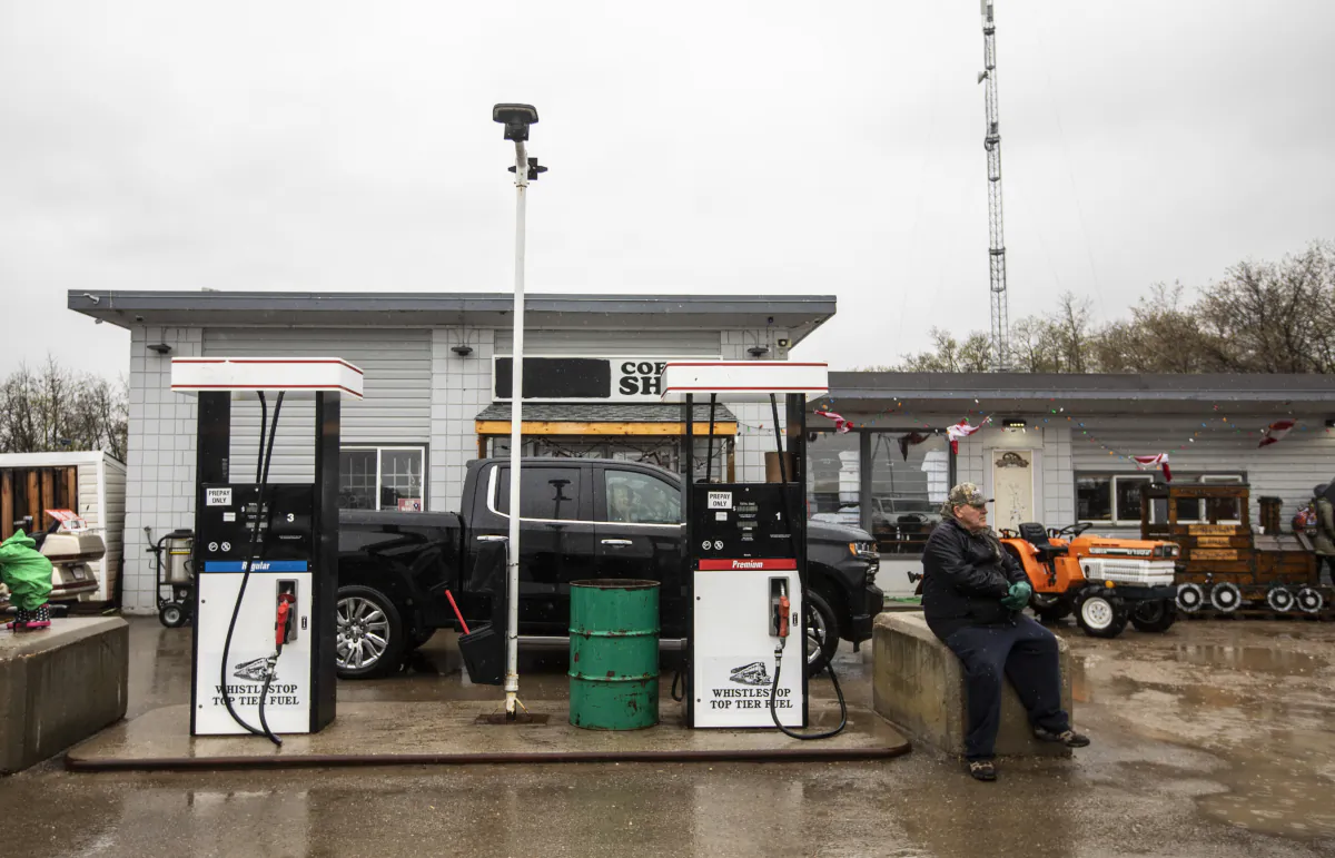 A supporter sits outside the Whistle Stop cafe during a freedom rally in Mirror, Alberta, on May 8, 2021. (Jason Franson/The Canadian Press)