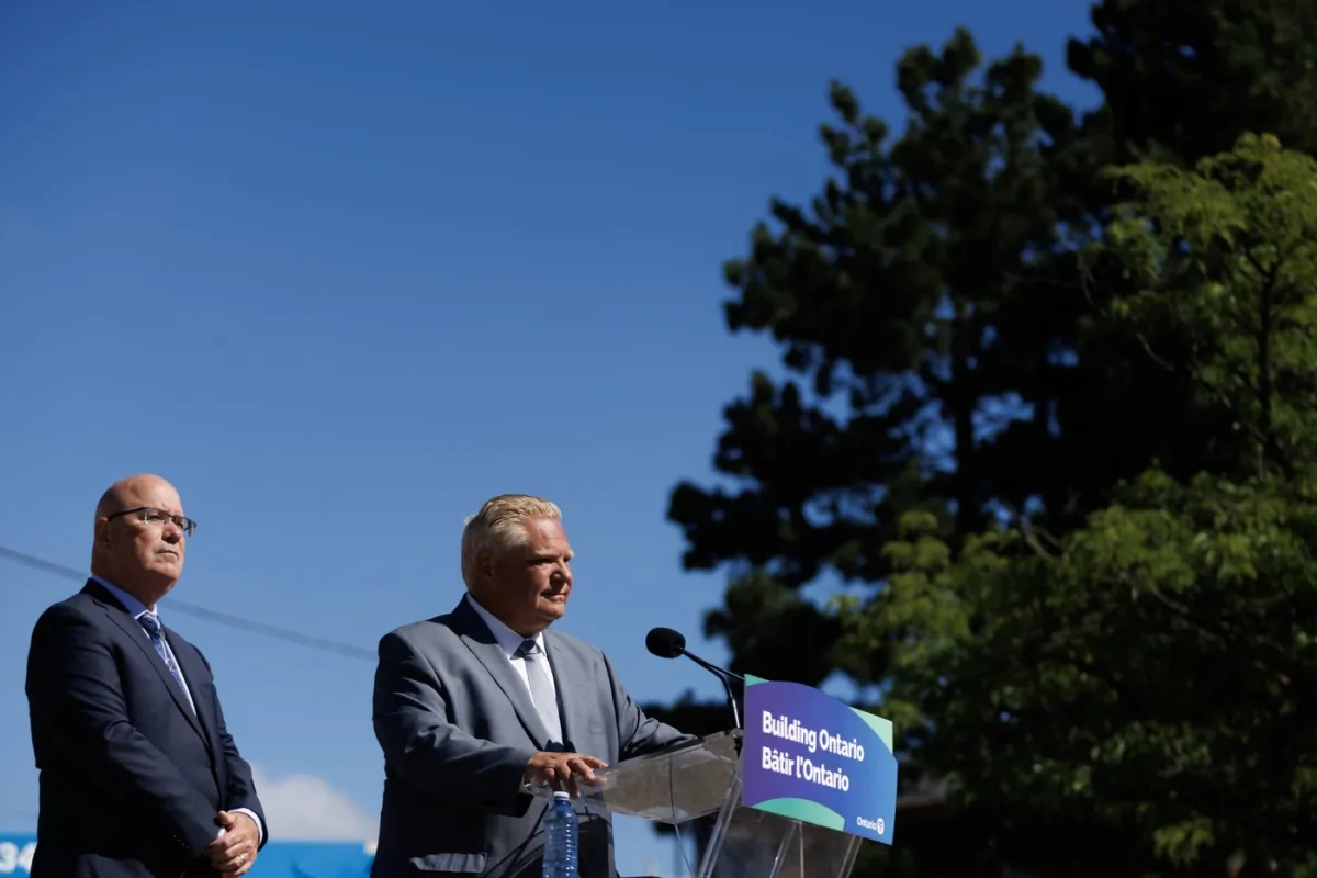 Ontario’s minister of housing Steve Clark listens as Premier Doug Ford speaks during a press conference in Mississauga, Ont., on Aug. 11, 2023. (The Canadian Press/Cole Burston)