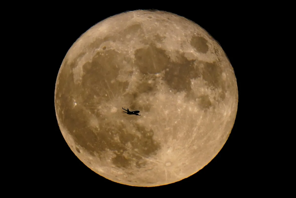 A plane passes in front of a supermoon in Milwaukee on July 13, 2022. (Morry Gash/AP Photo)
